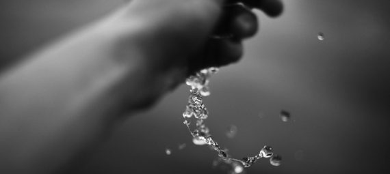 Hand pouring water in black and white