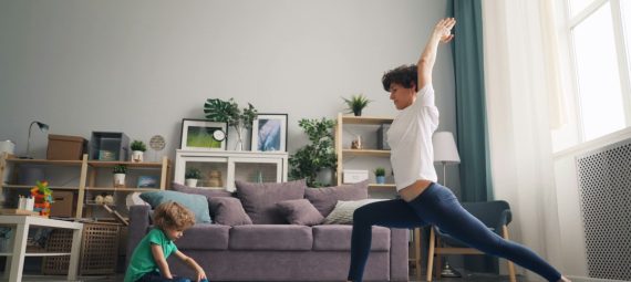 a woman and a child doing yoga in a living room